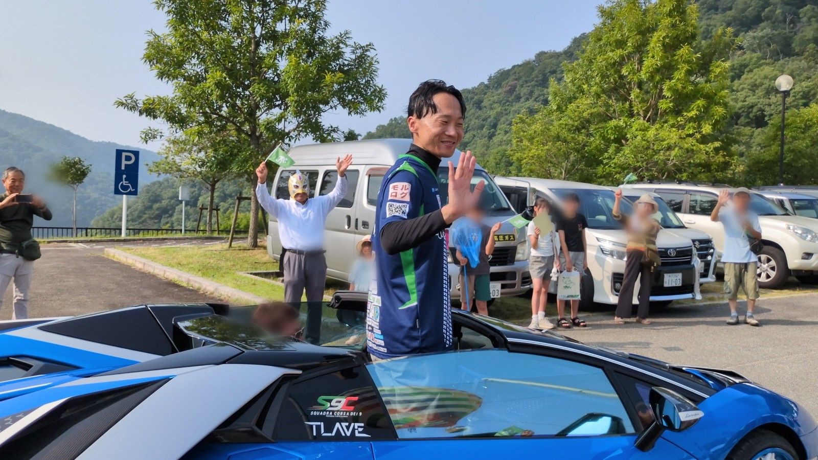 スポーツオープンカーから手を振って出発